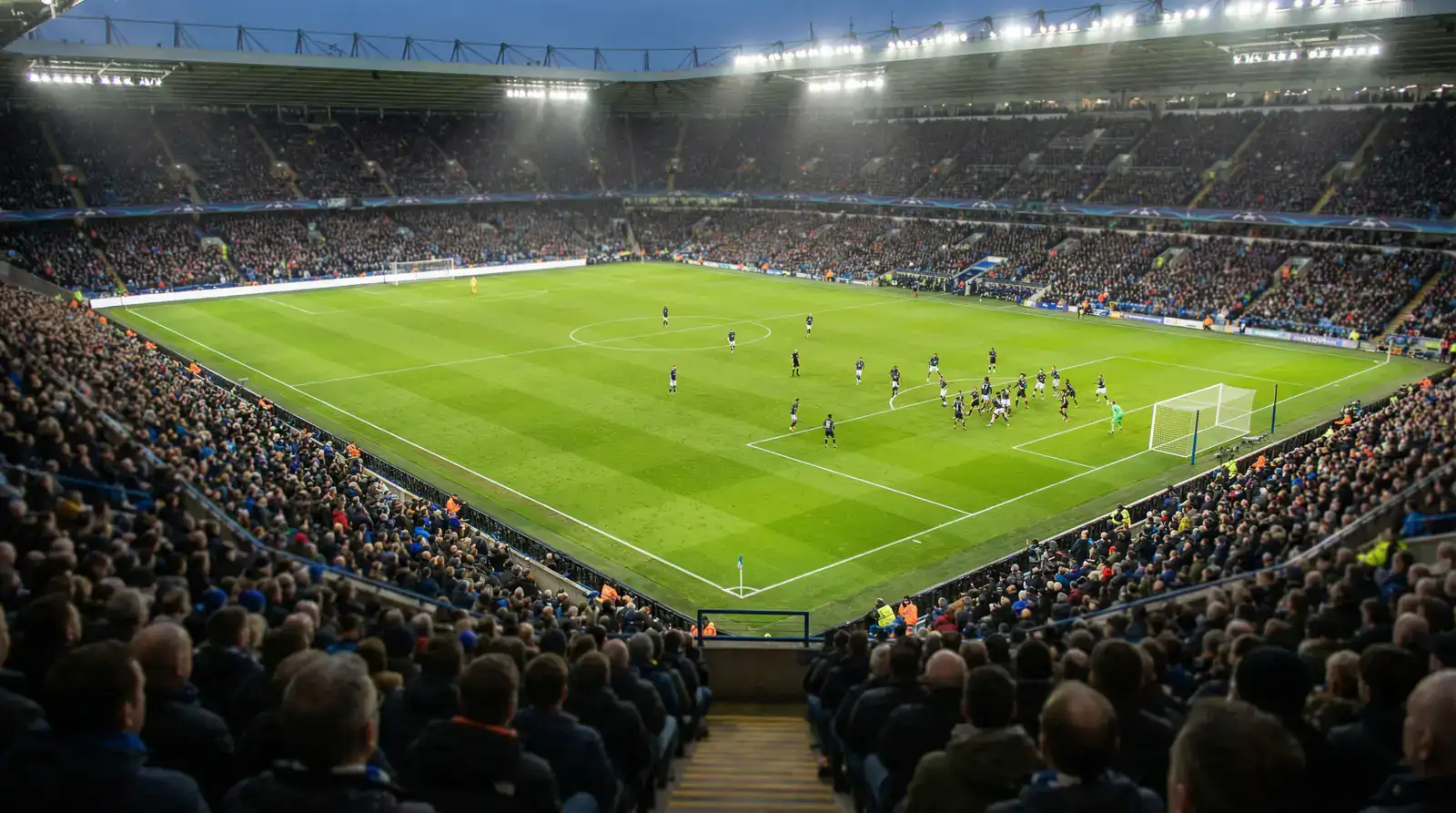 Vista desde las gradas de un partido de fútbol mostrando la disposición táctica de los equipos