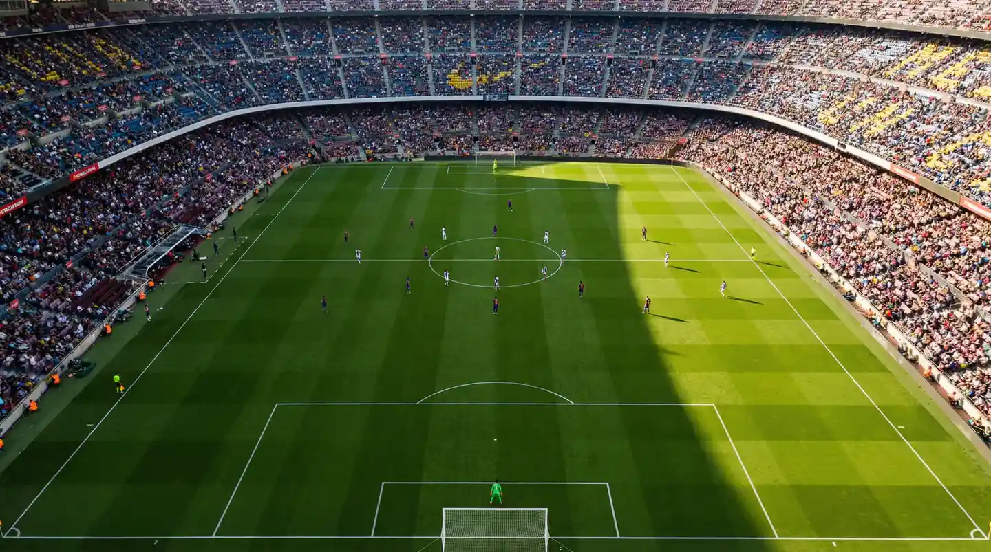 Vista aérea de estadio de fútbol profesional durante partido con aficionados, representando las múltiples posibilidades de apuesta